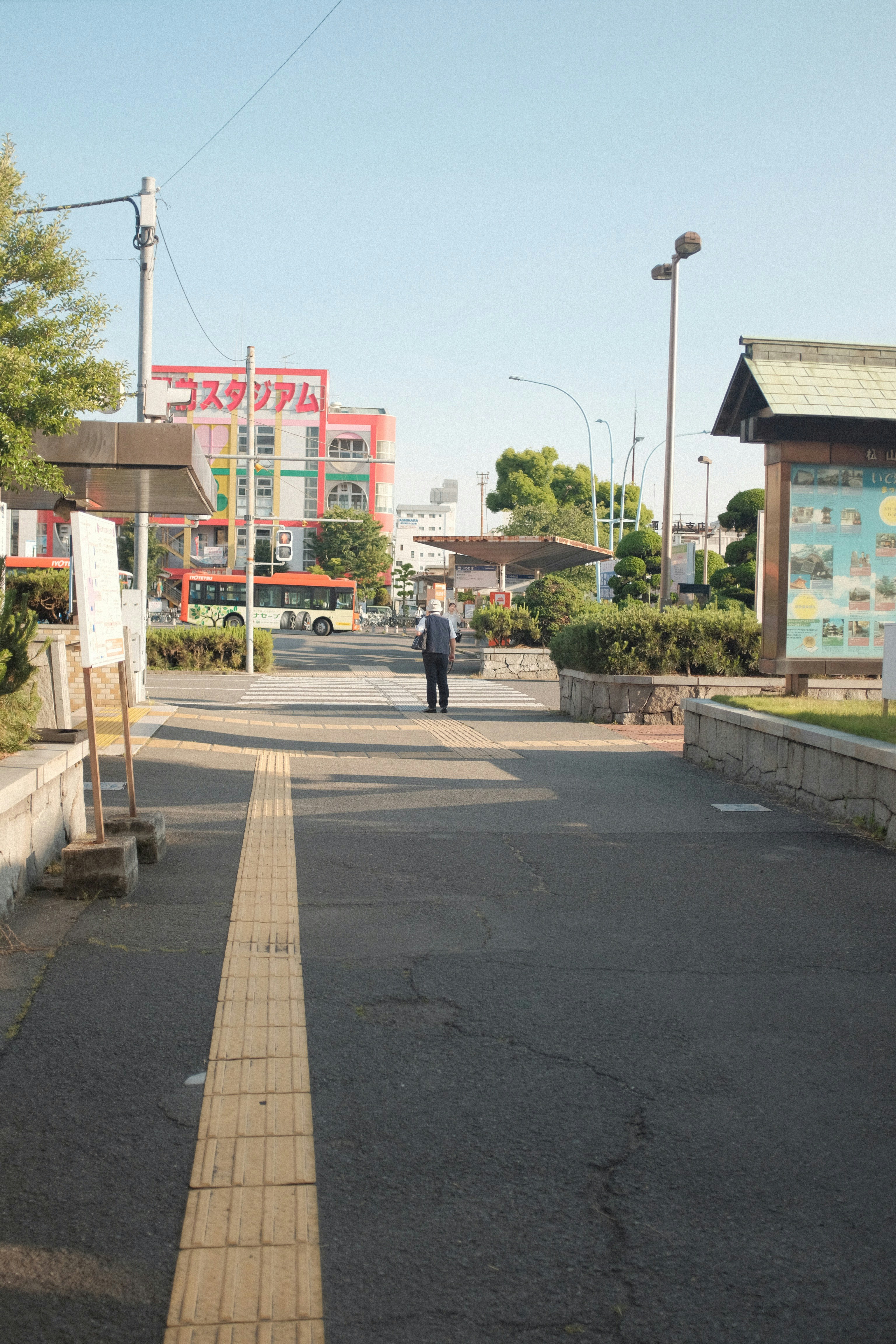 man in black jacket and black pants walking on sidewalk during daytime